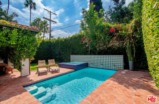 view of swimming pool featuring an in ground hot tub and a patio