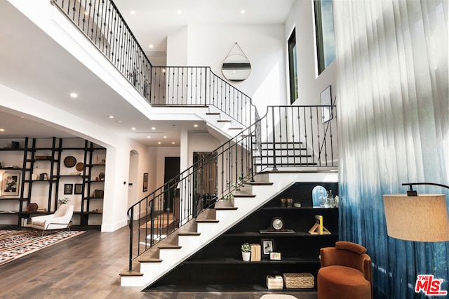 stairs with a high ceiling and hardwood / wood-style flooring