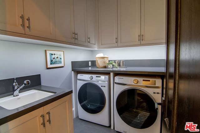 laundry area with washer and clothes dryer, cabinets, and sink