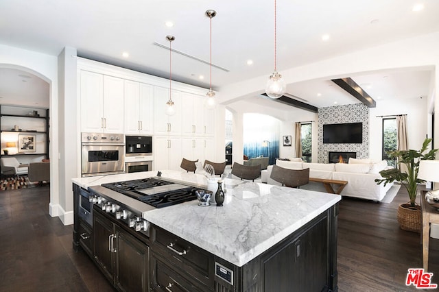 kitchen featuring pendant lighting, a center island, dark hardwood / wood-style floors, white cabinetry, and stainless steel appliances