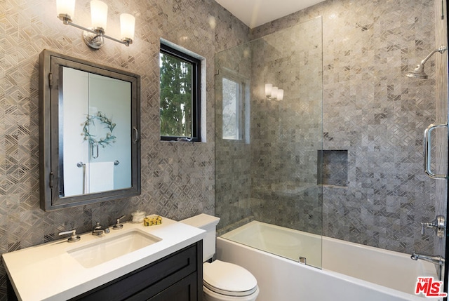 full bathroom with vanity, toilet, and enclosed tub / shower combo