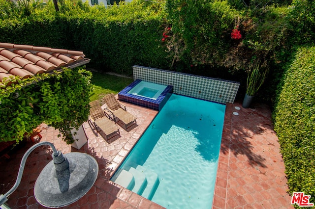 view of pool featuring an in ground hot tub and a patio