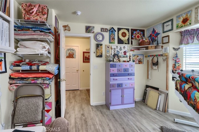 walk in closet with light hardwood / wood-style flooring