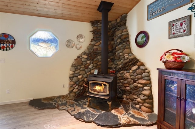 room details featuring wood-type flooring, wood ceiling, and a wood stove