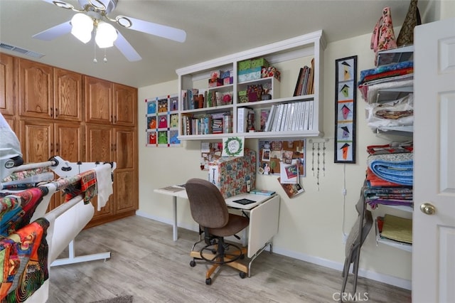 home office with ceiling fan and light hardwood / wood-style flooring