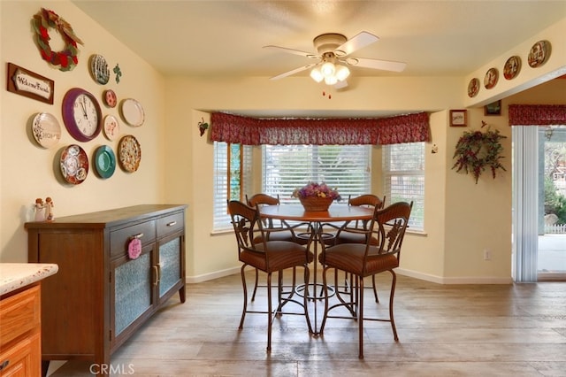 dining room featuring ceiling fan, light wood-type flooring, and a healthy amount of sunlight