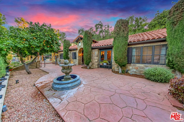 patio terrace at dusk featuring french doors