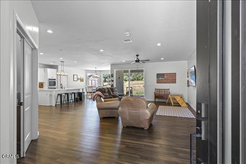 living room with dark hardwood / wood-style flooring and ceiling fan