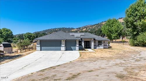 view of front facade featuring a mountain view, a garage, and solar panels