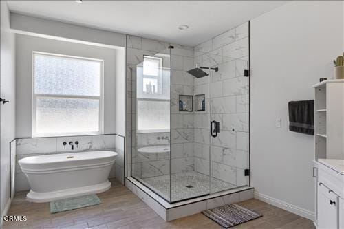 bathroom with wood-type flooring, vanity, and separate shower and tub