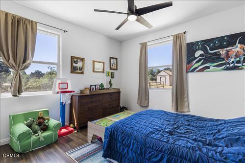 bedroom with multiple windows, hardwood / wood-style floors, and ceiling fan