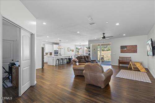 living room featuring ceiling fan and dark hardwood / wood-style flooring