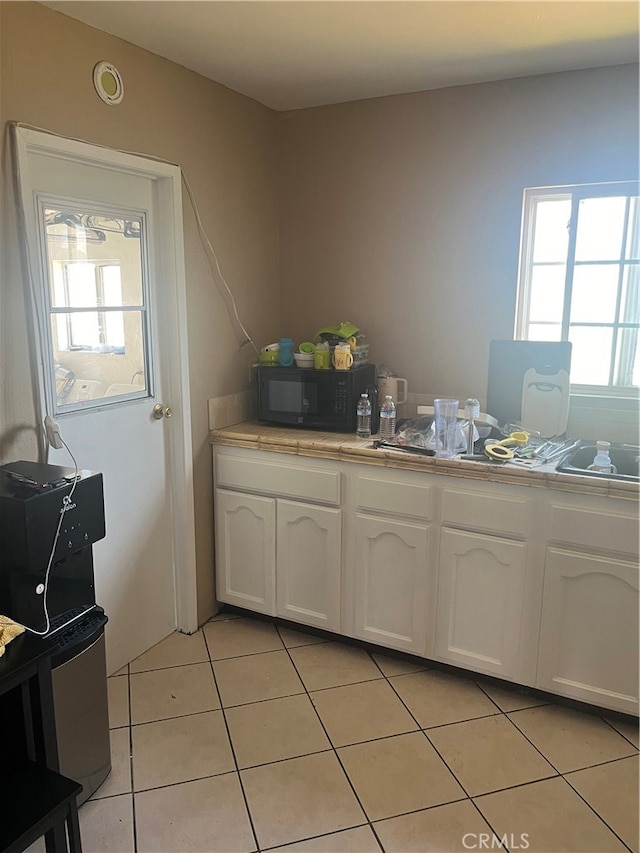 kitchen featuring white cabinets and light tile patterned floors