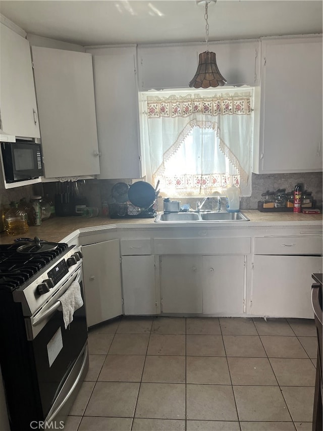 kitchen featuring white range with gas stovetop, sink, decorative backsplash, and white cabinetry