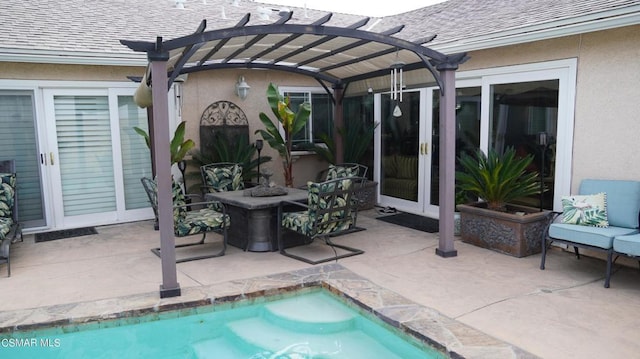 view of swimming pool featuring a patio area, a pergola, an outdoor fire pit, and french doors