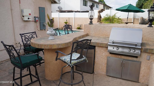 view of patio featuring area for grilling, an outdoor bar, and electric panel