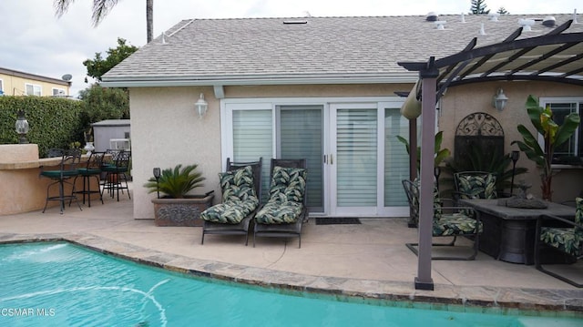 view of pool with a pergola, a patio area, and a bar