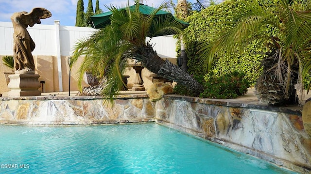 view of swimming pool with pool water feature