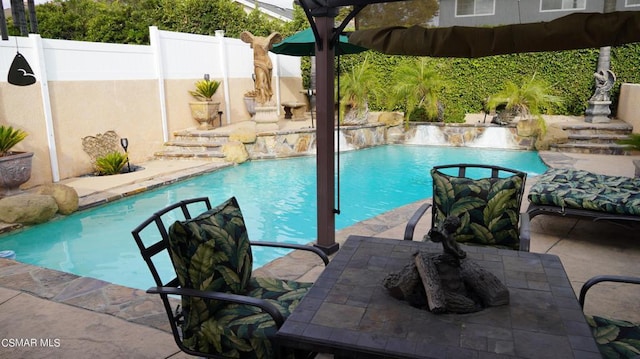 view of swimming pool with a fire pit and a patio