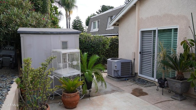 view of patio / terrace with a shed and central air condition unit