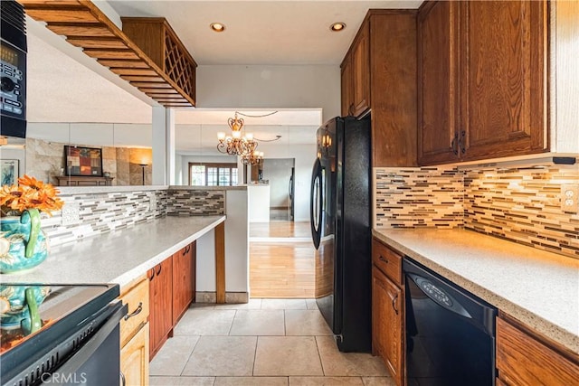 kitchen with black appliances, decorative light fixtures, backsplash, a chandelier, and light tile patterned floors