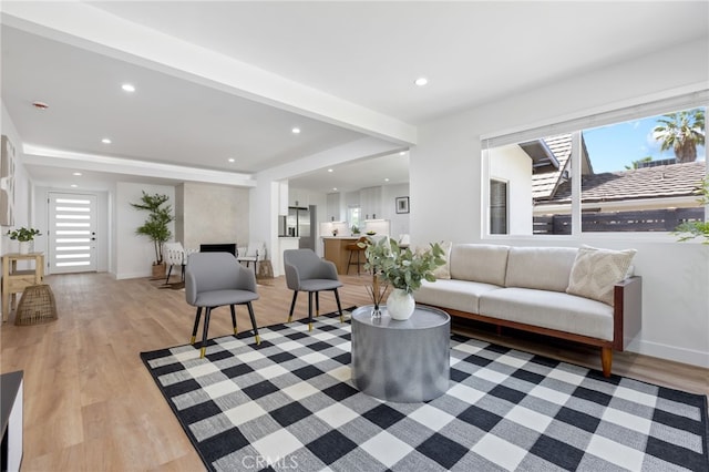 living room with beam ceiling and light wood-type flooring