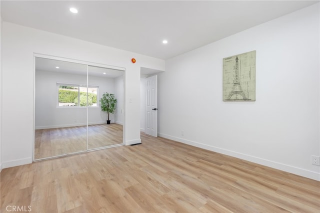 unfurnished bedroom featuring a closet and light hardwood / wood-style floors