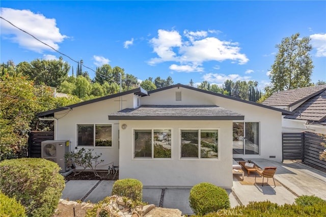 rear view of property with ac unit and a patio area