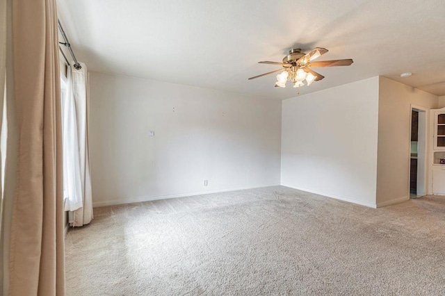 spare room with ceiling fan and light carpet