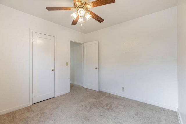 unfurnished bedroom featuring light colored carpet and ceiling fan