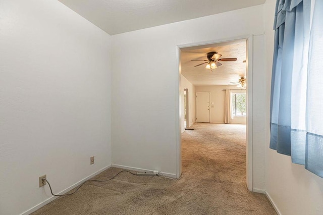 carpeted spare room featuring ceiling fan