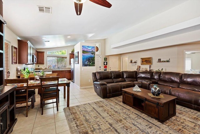 living room featuring ceiling fan, light tile patterned floors, and lofted ceiling