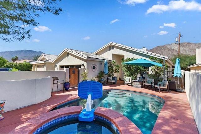 view of pool with a patio area, an in ground hot tub, a mountain view, and an outdoor bar