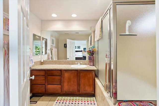 bathroom featuring vanity, tile patterned floors, and a shower with shower door