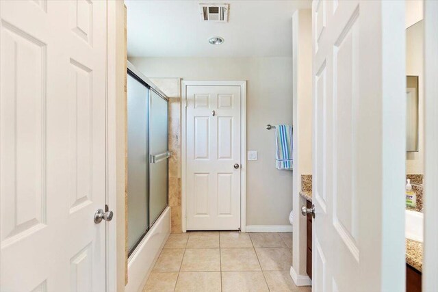 full bathroom featuring tile patterned flooring, vanity, toilet, and combined bath / shower with glass door