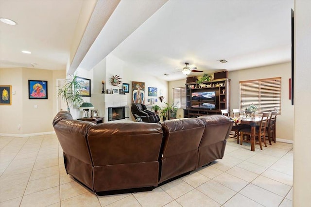 living room featuring ceiling fan, light tile patterned floors, and lofted ceiling