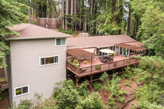 rear view of house featuring a pergola and a deck