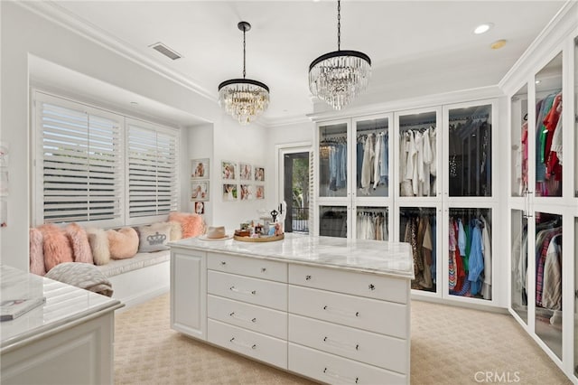 spacious closet featuring an inviting chandelier and light colored carpet