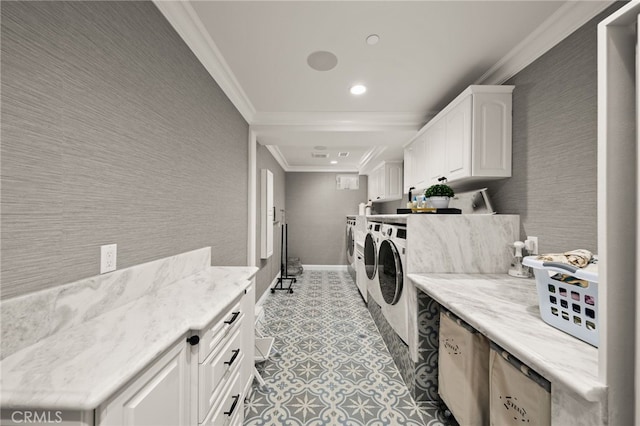 washroom with cabinets, crown molding, and washing machine and clothes dryer