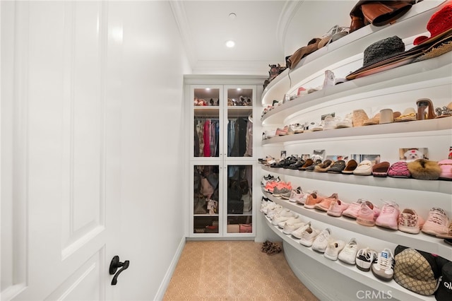 spacious closet featuring light colored carpet