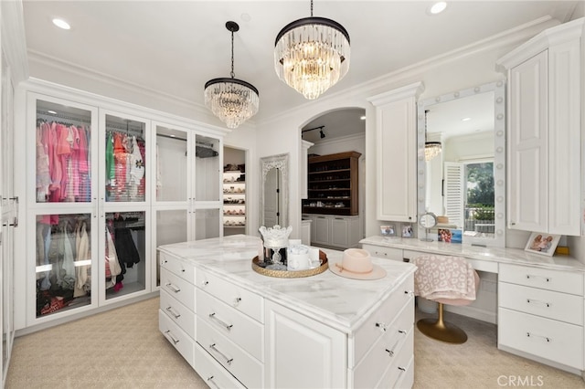 spacious closet with a notable chandelier and light colored carpet