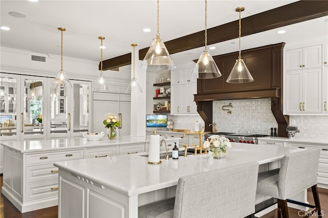 kitchen with a spacious island, a kitchen breakfast bar, white cabinetry, and decorative light fixtures