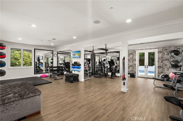 gym with ornamental molding, hardwood / wood-style floors, and french doors