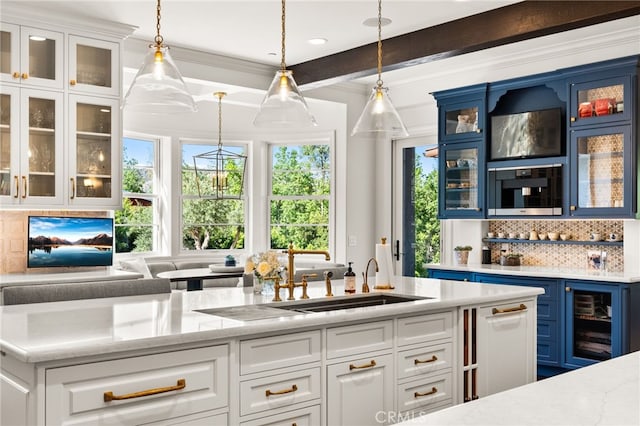 bar featuring decorative backsplash, sink, pendant lighting, white cabinets, and light stone counters