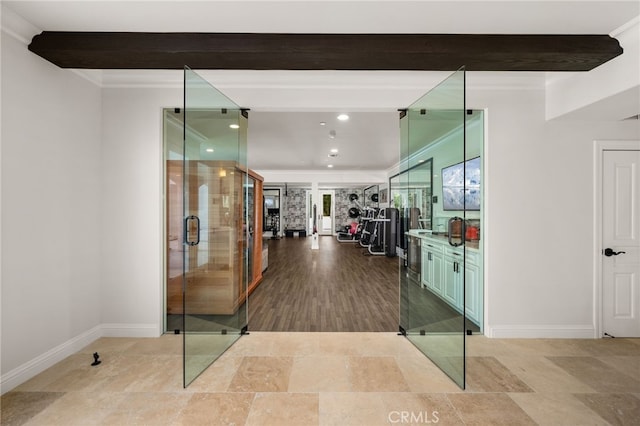 hallway featuring light hardwood / wood-style floors, ornamental molding, and beam ceiling