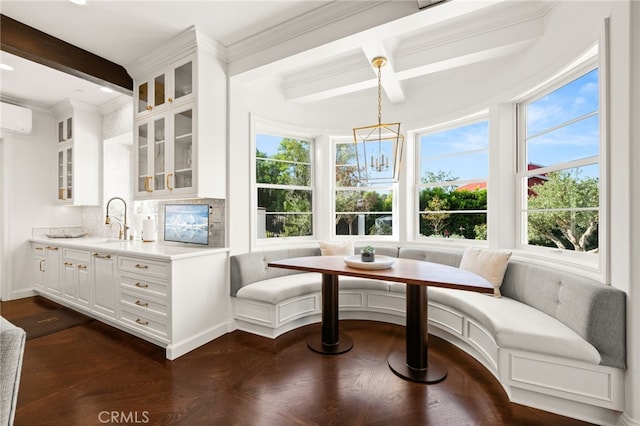 dining space featuring beam ceiling, breakfast area, sink, and a healthy amount of sunlight