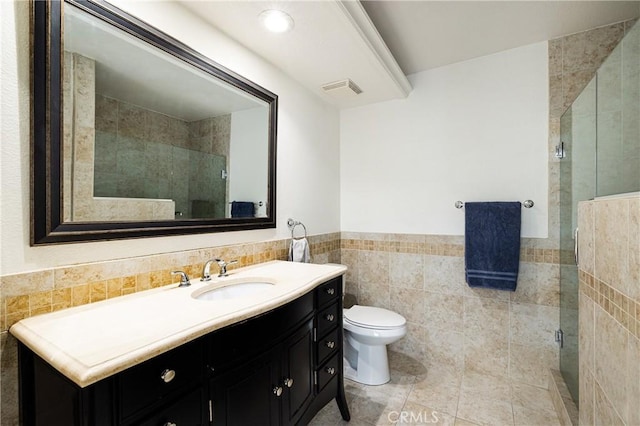 bathroom with toilet, vanity, tile walls, walk in shower, and tile patterned floors