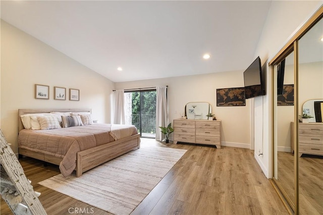 bedroom with a closet, lofted ceiling, and light hardwood / wood-style floors