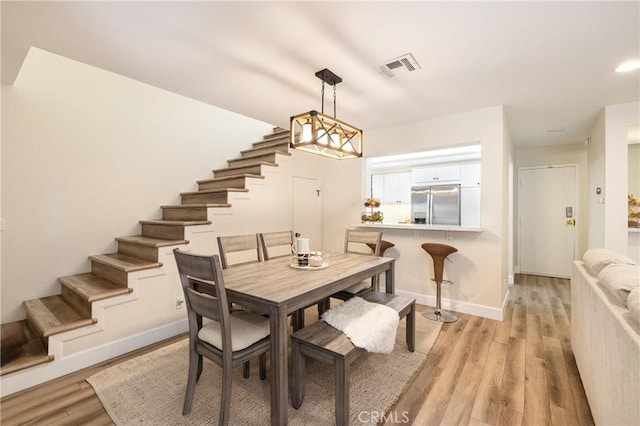 dining area featuring light hardwood / wood-style floors and a notable chandelier