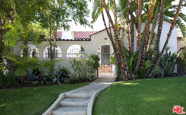 mediterranean / spanish house featuring a front lawn